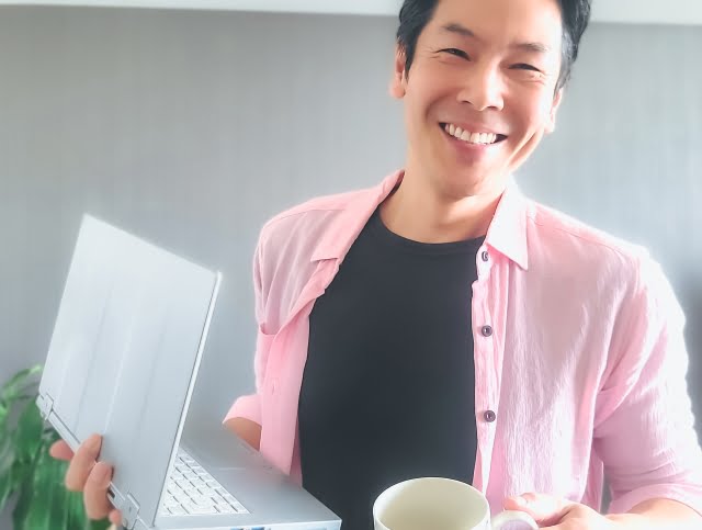 嬉しそうにパソコンを見せる男性